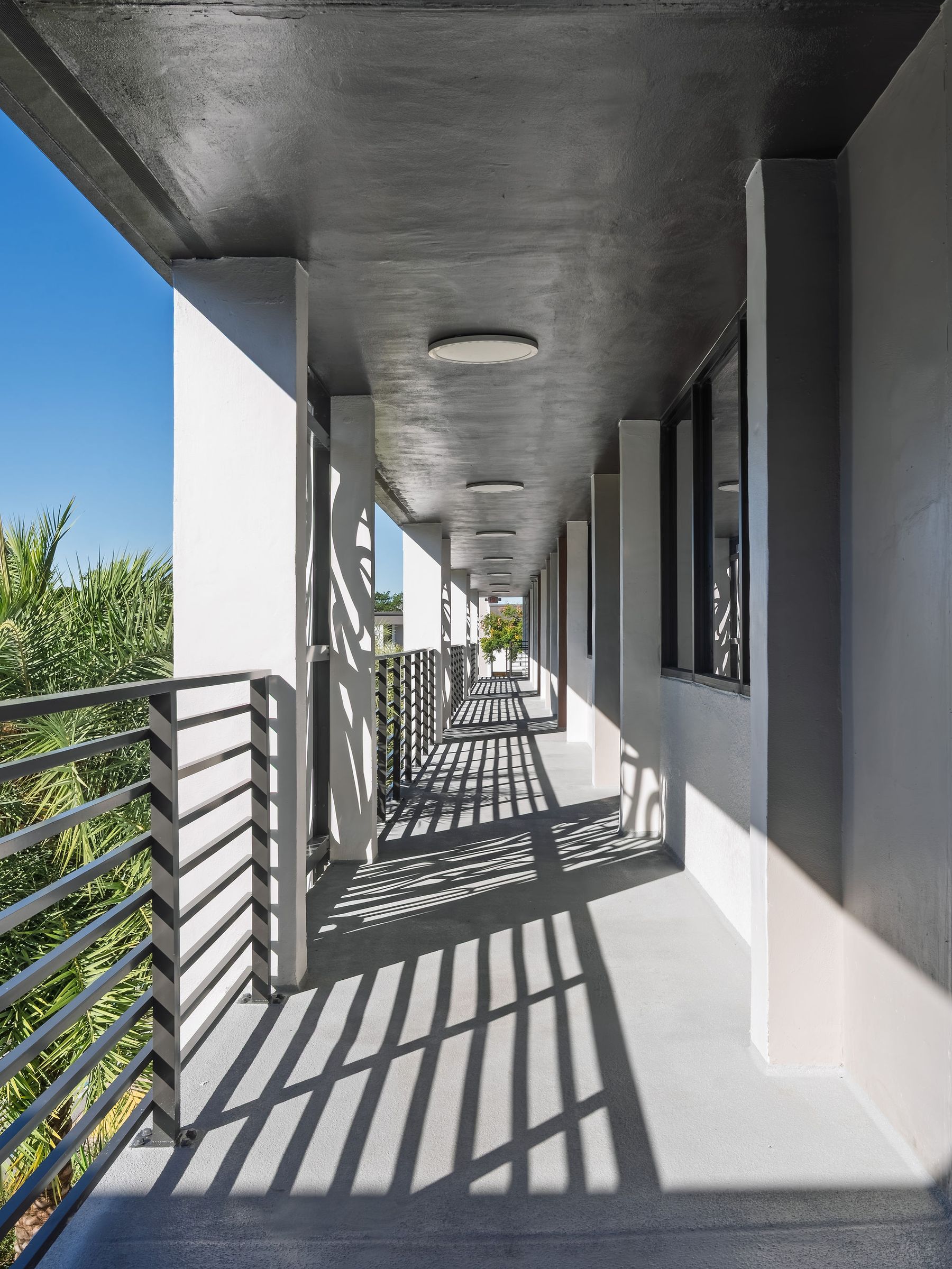 Sunlit covered walkway lined with columns at the office park