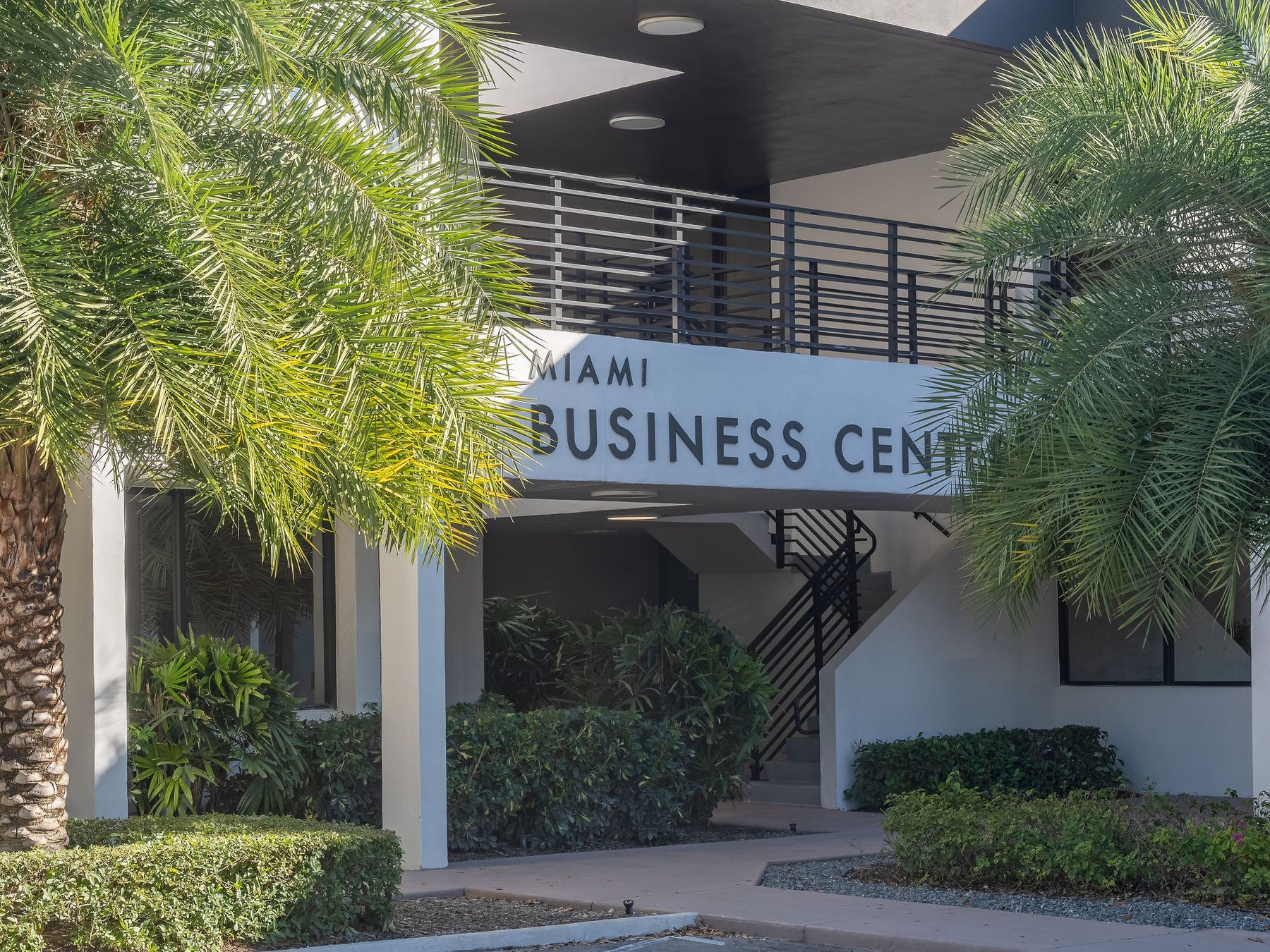 Entrance signage reading Miami Business Center framed by palms